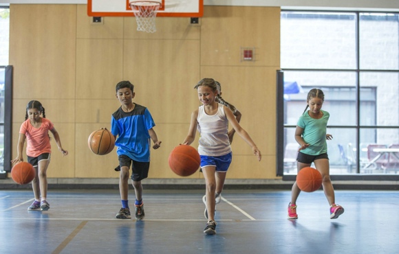 Children bouncing basketballs