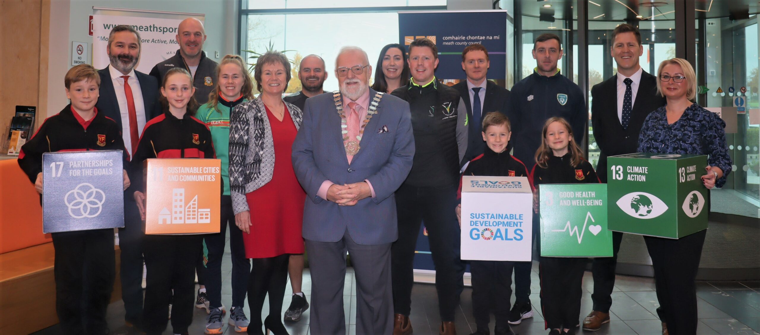 Pictured L to R – Cllr David Gilroy (Project Team), Damien Sheridan (Meath GAA GPO), Stacey Grimes (Meath LGFA GDO), Jackie Maguire (CEO, Meath County Council), Niall Kane (Leinster Rugby DO], Cllr Nick Killian (Cathaoirleach, Meath County Council), Alison Lynch (Meath LSP Board Member), Ruairi Murphy (Meath LSP Programme Manager), Dara McGowan (Director of Services, Meath County Council), Richie Smith (FAI DO), Patrick Haslett (Managing Partner, Impact 3 Zero), Mary D’Arcy (Climate Change Co-Ordinator, Meath County Council) with pupils of Yellow Furze N.S.