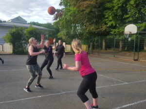 Women playing basketball outside