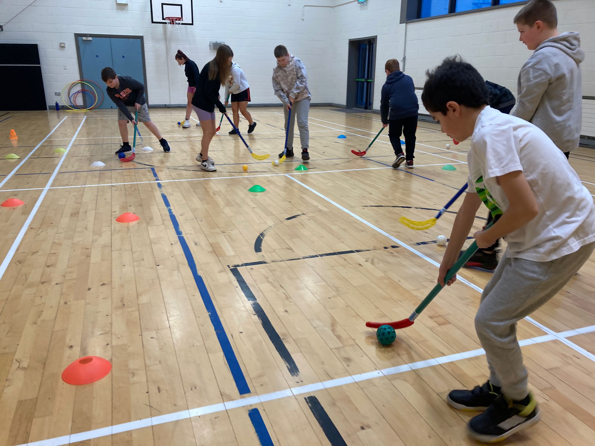 Kids playing hockey in a hall