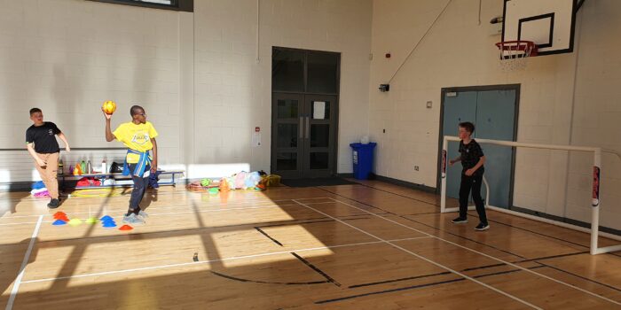 Kids throwing a ball in a hall